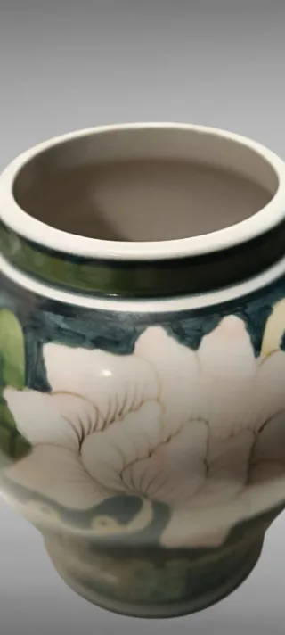 Jarrón de cerámica verde con flores