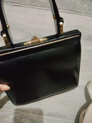 Bolso de mano negro con detalles dorados