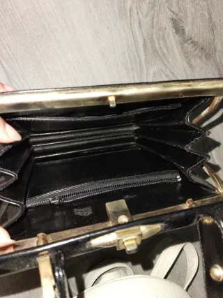Bolso de mano negro con detalles dorados