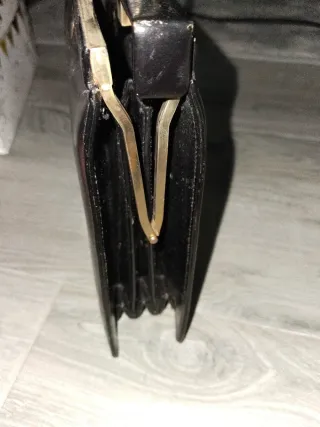 Bolso de mano negro con detalles dorados