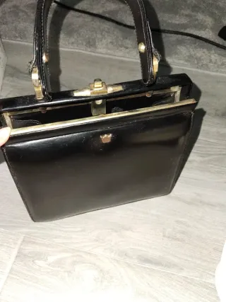 Bolso de mano negro con detalles dorados