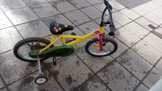Bicicleta infantil amarilla con ruedines