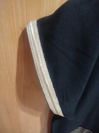 Vestido negro con detalles dorados.