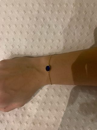 Pulsera dorada con piedra azul ovalada