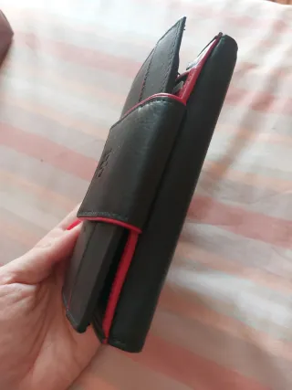 Cartera de piel negra con detalles rojos