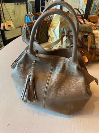 borsa a mano in pelle martellata con nappe.