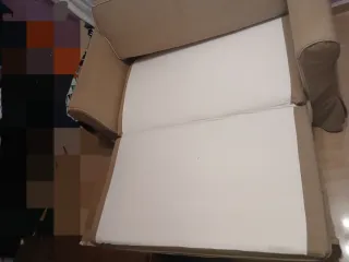 Sofá cama beige de tela y fundas blancas incluidas