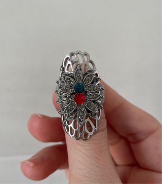 Anillo plateado con pedrería roja y verde