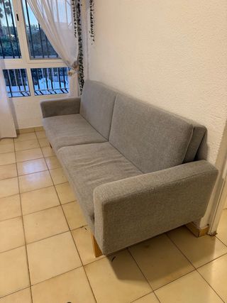 Sofá de tela gris con patas nordicas