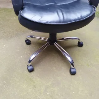 Sillón de despacho negro con ruedas.