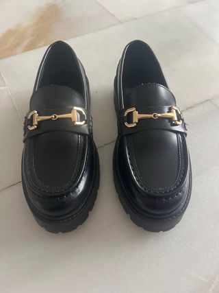 Mocasines negros con hebilla dorada