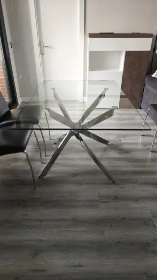 Mesa de comedor de cristal y metal.
