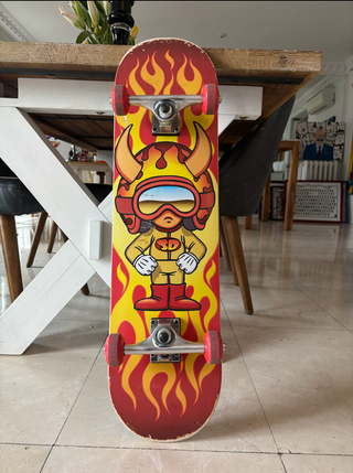 Patineta con diseño de fuego y demonio