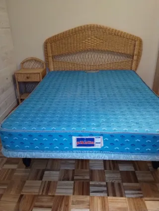 Cama Matrimonial con cabecero y mesita de mimbre.
