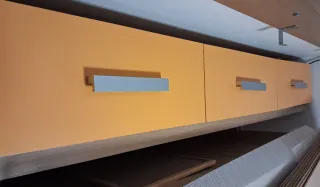 Mueble bajo cama naranja con tiradores plateados
