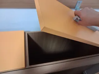 Mueble bajo cama naranja con tiradores plateados