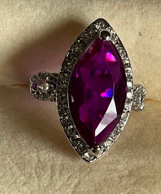 Anello con grande gemma viola e cristalli luminosi