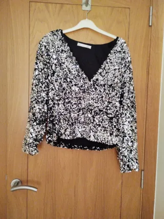 Jersey pico lentejuelas negro y plata.