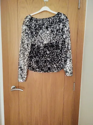 Jersey pico lentejuelas negro y plata.