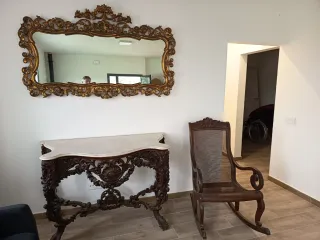 Antica sedia a dondolo in mogano e rattan