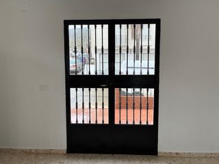 Puerta de forja con cristal.