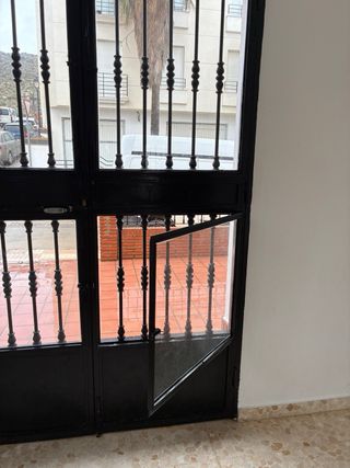 Puerta de forja con cristal.