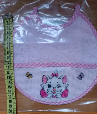 Babero bordado a mano punto de cruz, color rosa.