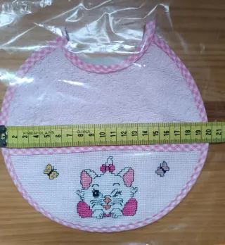 Babero bordado a mano punto de cruz, color rosa.