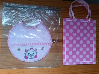 Babero bordado a mano punto de cruz, color rosa.