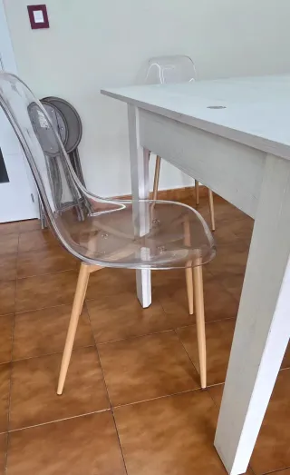 Mesa de comedor blanca y sillas transparentes