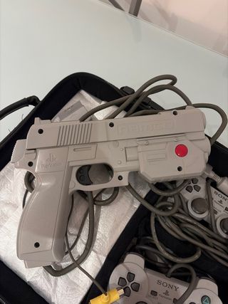 PlayStation con dos mandos y una pistola