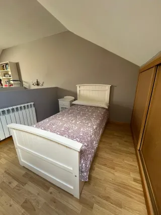 Cama individual blanca con cabecero y mesilla