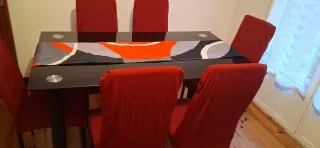 Mesa de comedor negra con sillas rojas