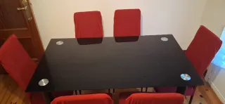 Mesa de comedor negra con sillas rojas