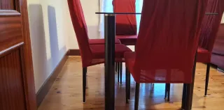 Mesa de comedor negra con sillas rojas