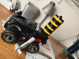 Coche de juguete negro con ruedas amarillas