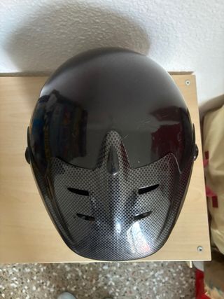Casco de moto negro con diseño de carbono