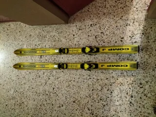 Botas de esquí rojas, tablas y bastones