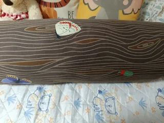 Cojín cilíndrico marrón con diseño de tronco