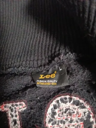 Sudadera negra con cremallera y detalles rojos