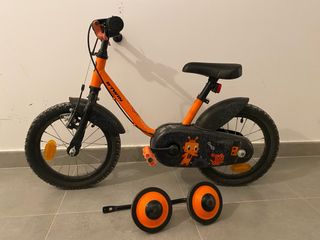 Bicicleta infantil naranja con ruedines (Decathlon