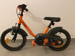 Bicicleta infantil naranja con ruedines (Decathlon