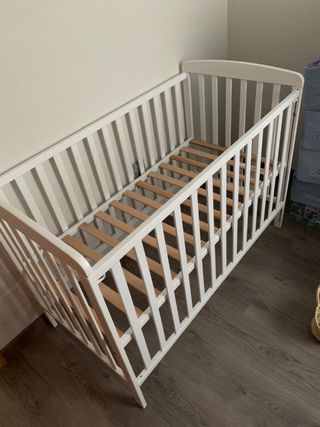 Cuna de bebé blanca de madera con colchon.