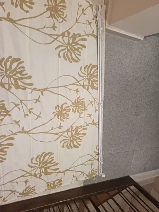 Cortina romana beige y dorada con flores.