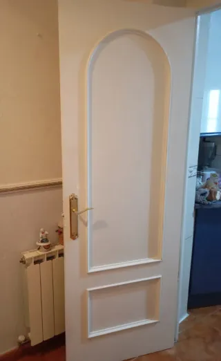 Puerta interior blanca de madera maciza.