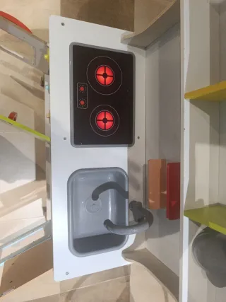 Cocina de juguete de madera con accesorios.