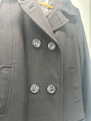 Elegante abrigo negro clásico doble botonadura