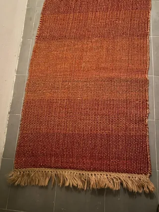 Alfombra tejida naranja y roja con flecos