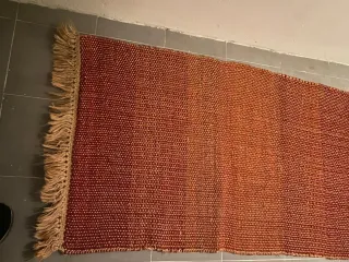 Alfombra tejida naranja y roja con flecos