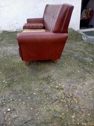 Sofá de cuero marrón con cojines. URGE VENTA